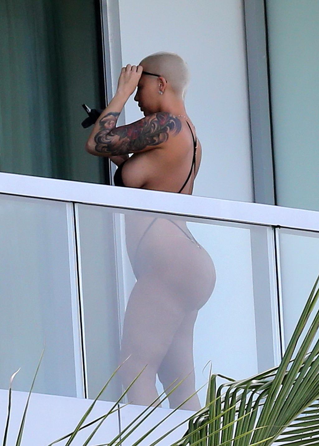16P Amber Rose shows off her round ass wearing a tiny black monokini on a hotel balc