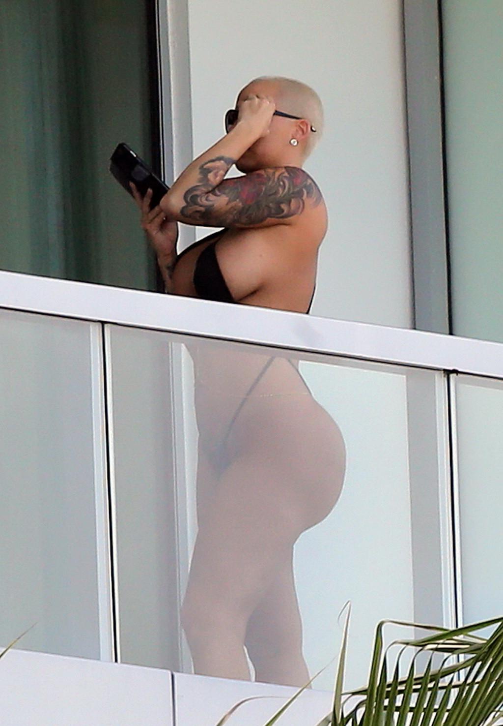 16P Amber Rose shows off her round ass wearing a tiny black monokini on a hotel balc