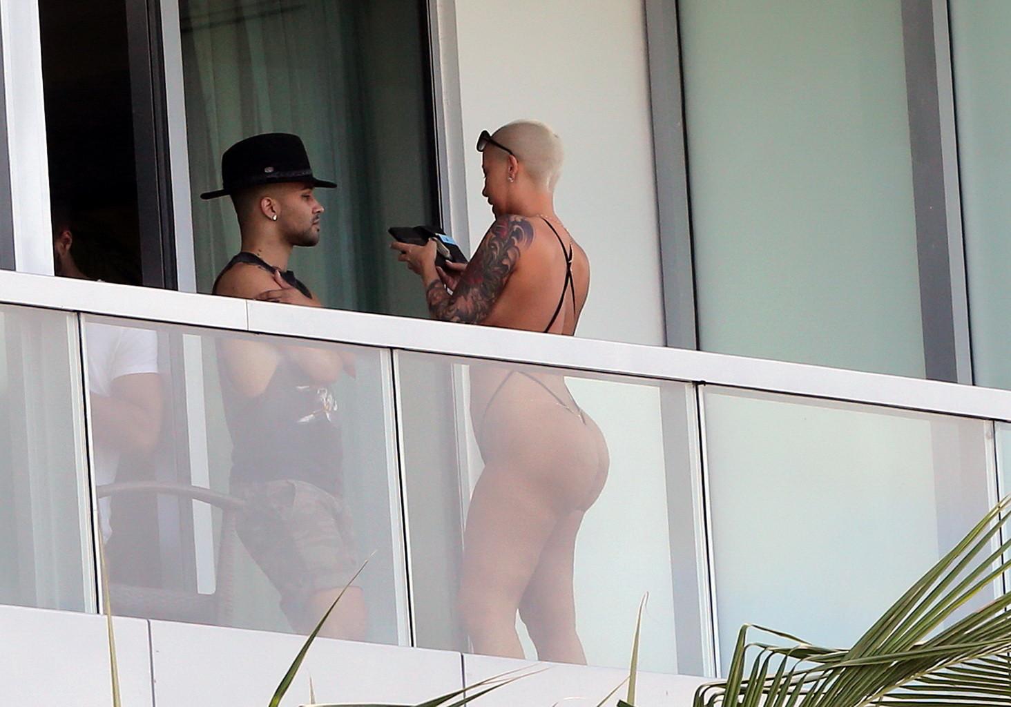 16P Amber Rose shows off her round ass wearing a tiny black monokini on a hotel balc