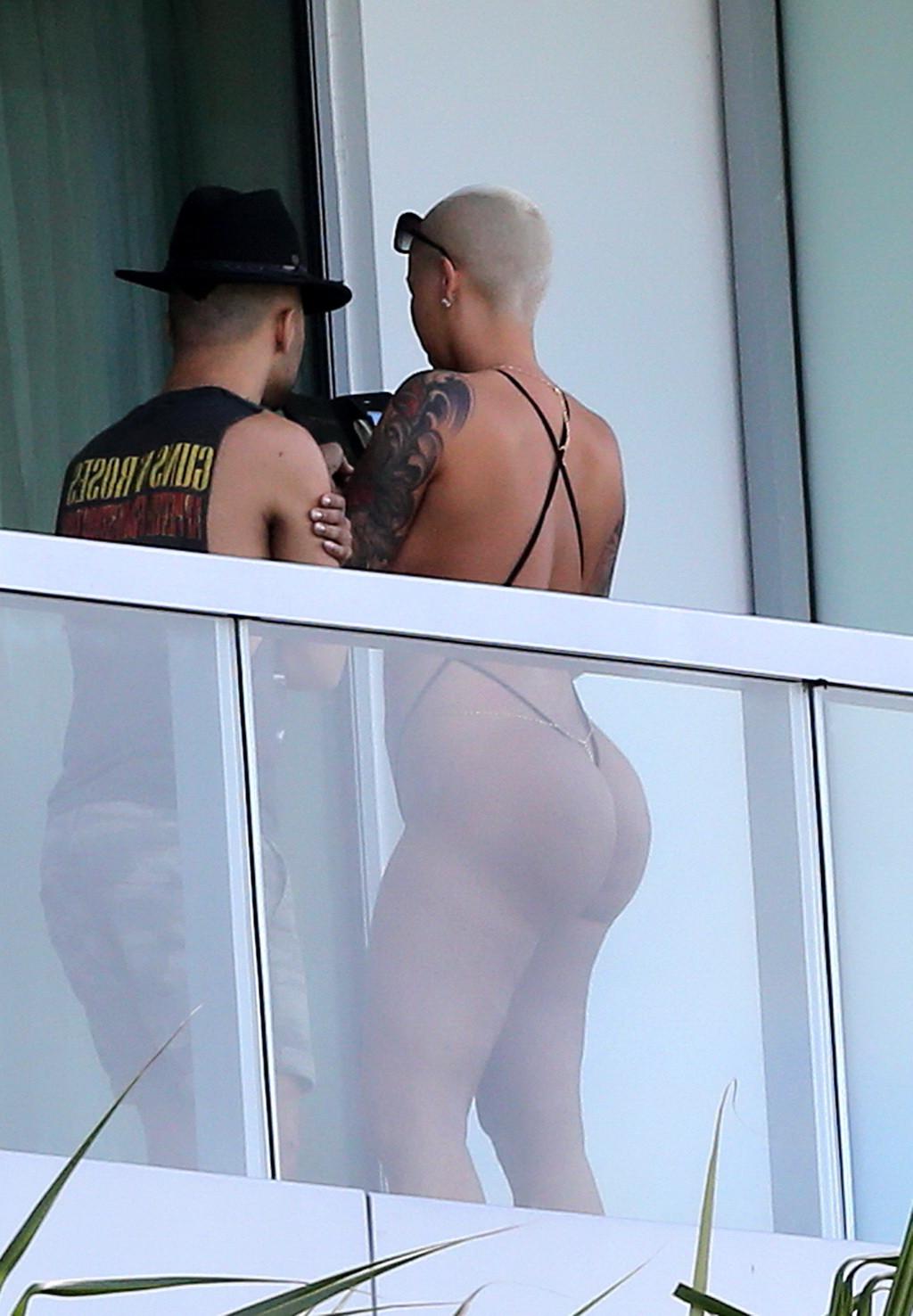 16P Amber Rose shows off her round ass wearing a tiny black monokini on a hotel balc
