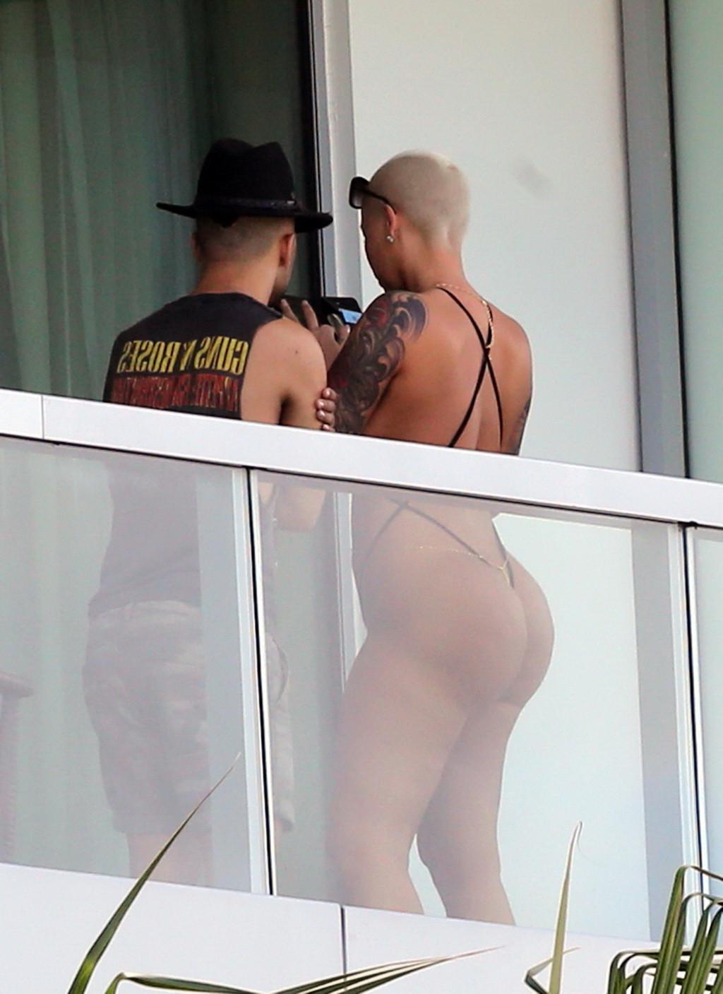 16P Amber Rose shows off her round ass wearing a tiny black monokini on a hotel balc