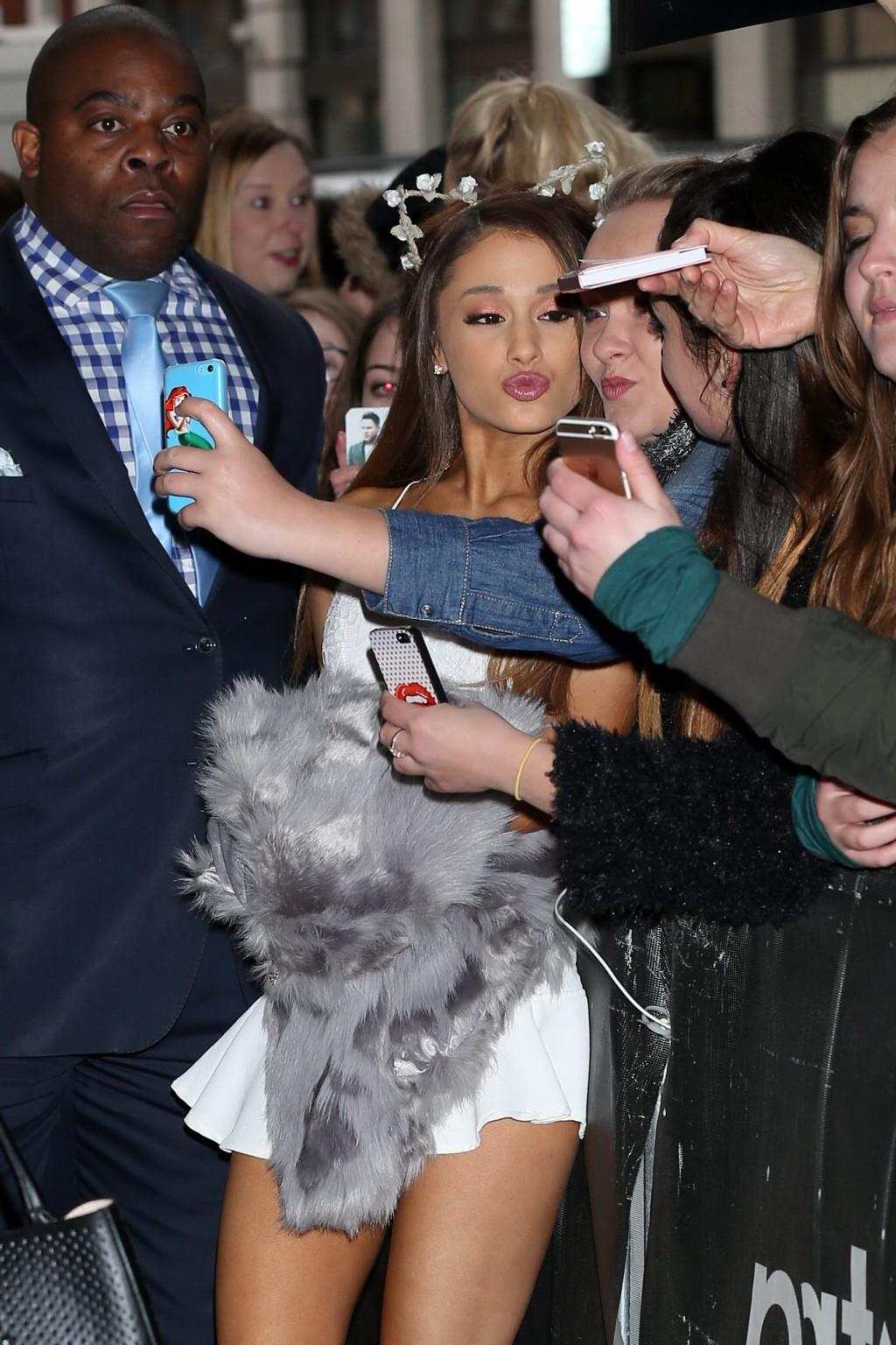16P Ariana Grande in tiny white mini skirt and belly top arriving at BBC Radio 1 Stu