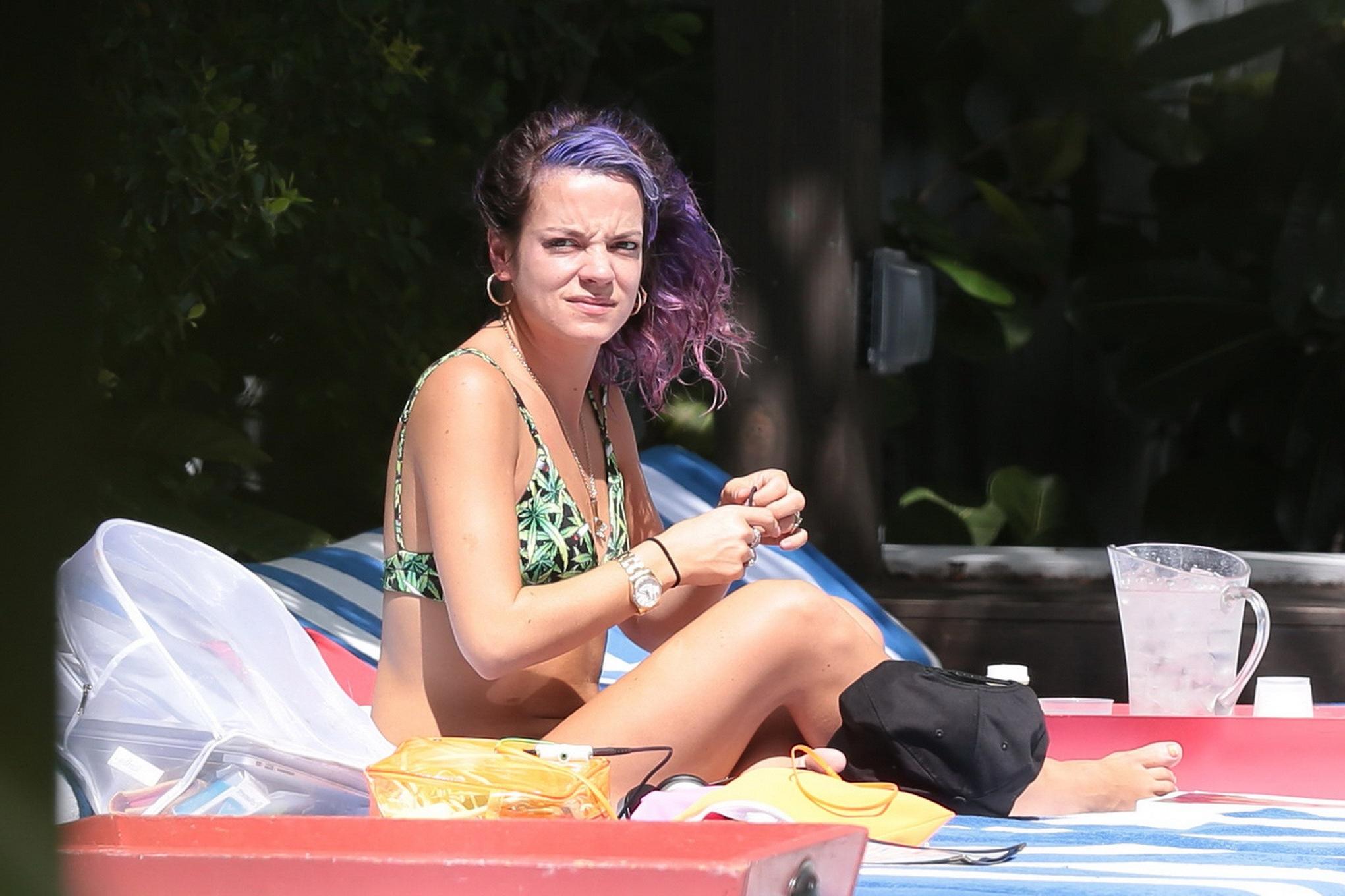 16P Lily Allen showing off her round butt in a leaf print bikini at the hotel pool i