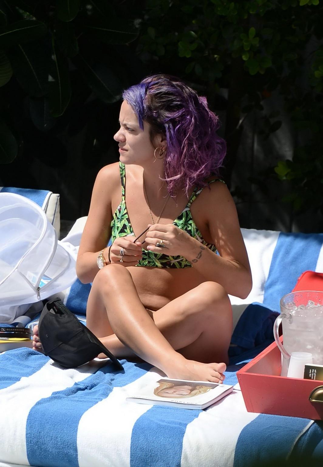 16P Lily Allen showing off her round butt in a leaf print bikini at the hotel pool i