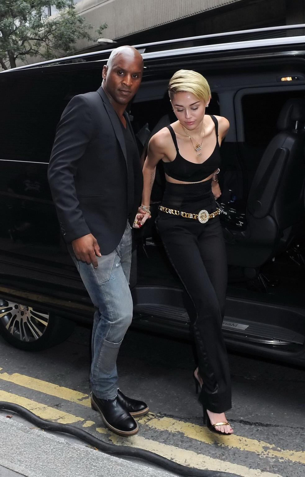 16P Miley Cyrus pantyless wearing black see-through pants and belly top outside her 