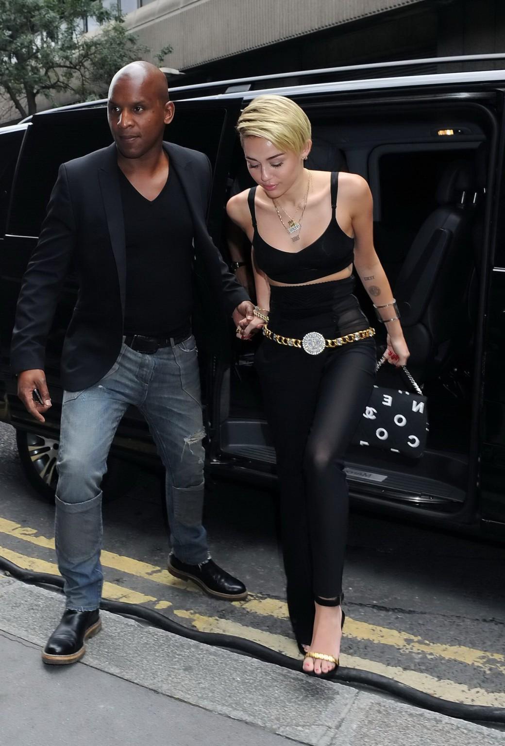 16P Miley Cyrus pantyless wearing black see-through pants and belly top outside her 