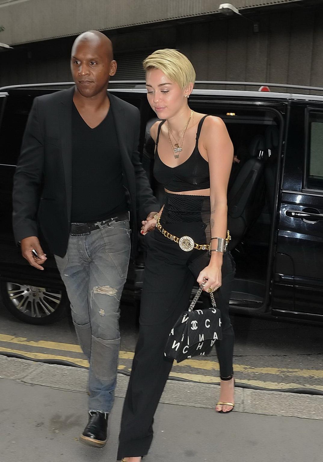 16P Miley Cyrus pantyless wearing black see-through pants and belly top outside her 