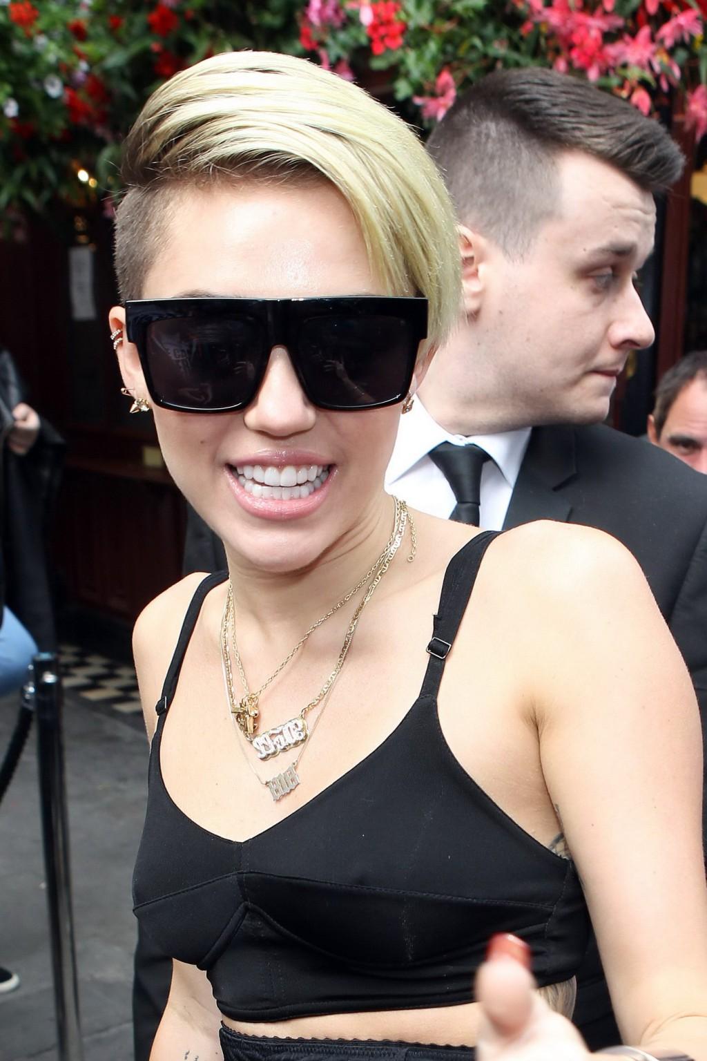 16P Miley Cyrus pantyless wearing black see-through pants and belly top outside her 