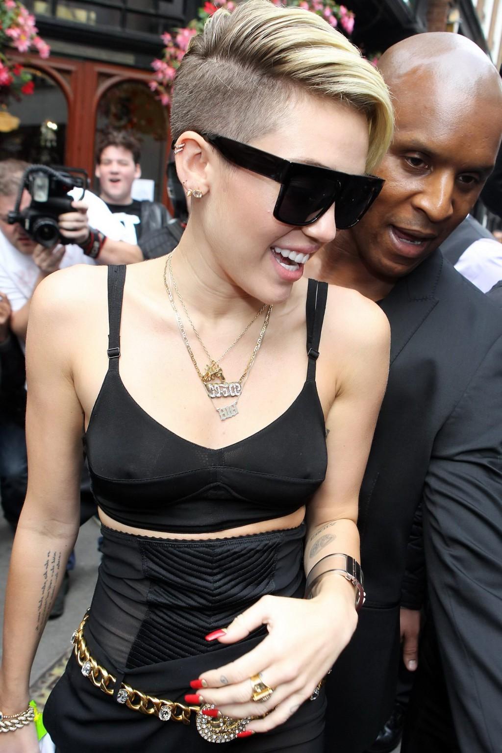 16P Miley Cyrus pantyless wearing black see-through pants and belly top outside her 