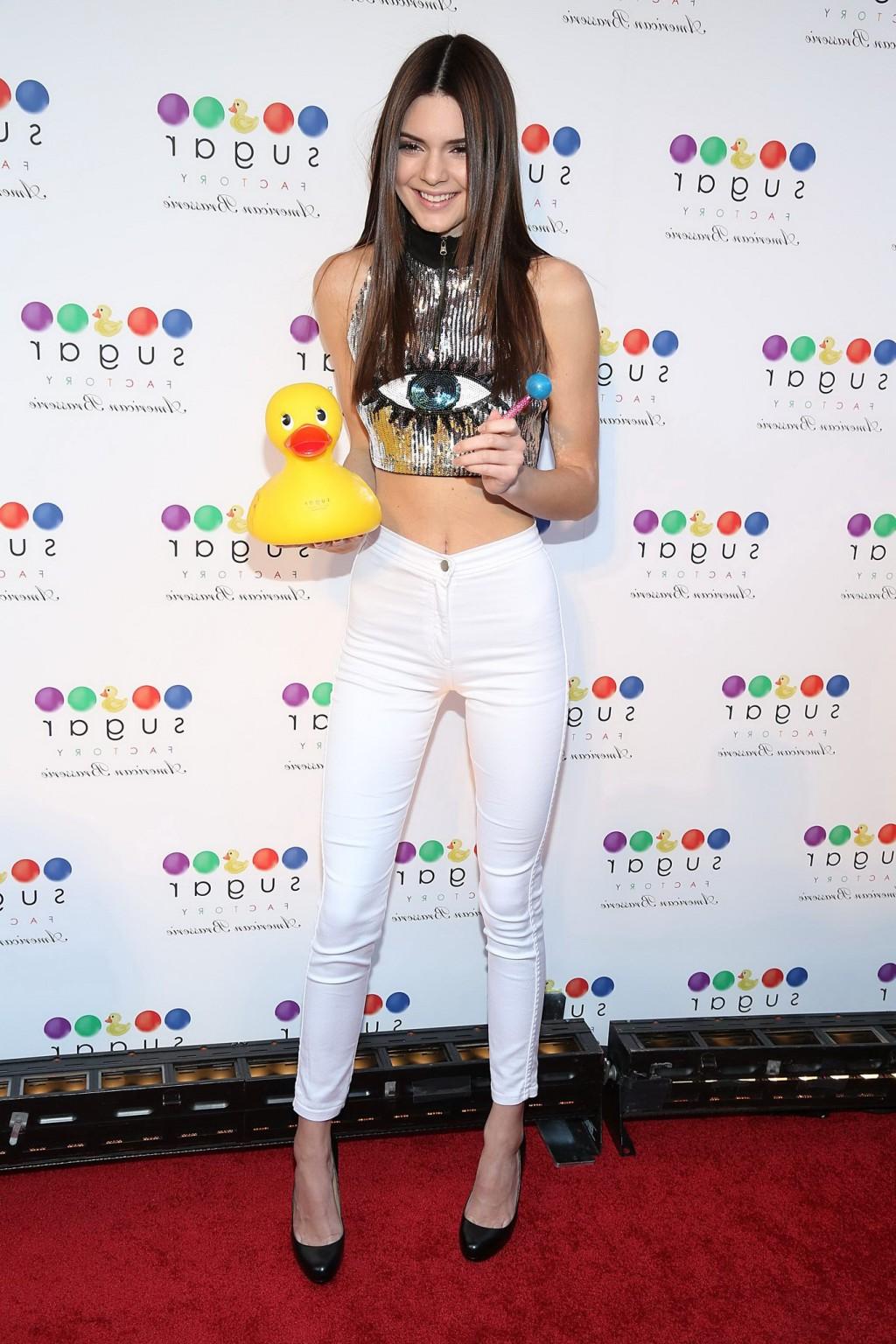 16P Kendall Jenner wearing tight belly top and white pants at the Sugar Factory gran