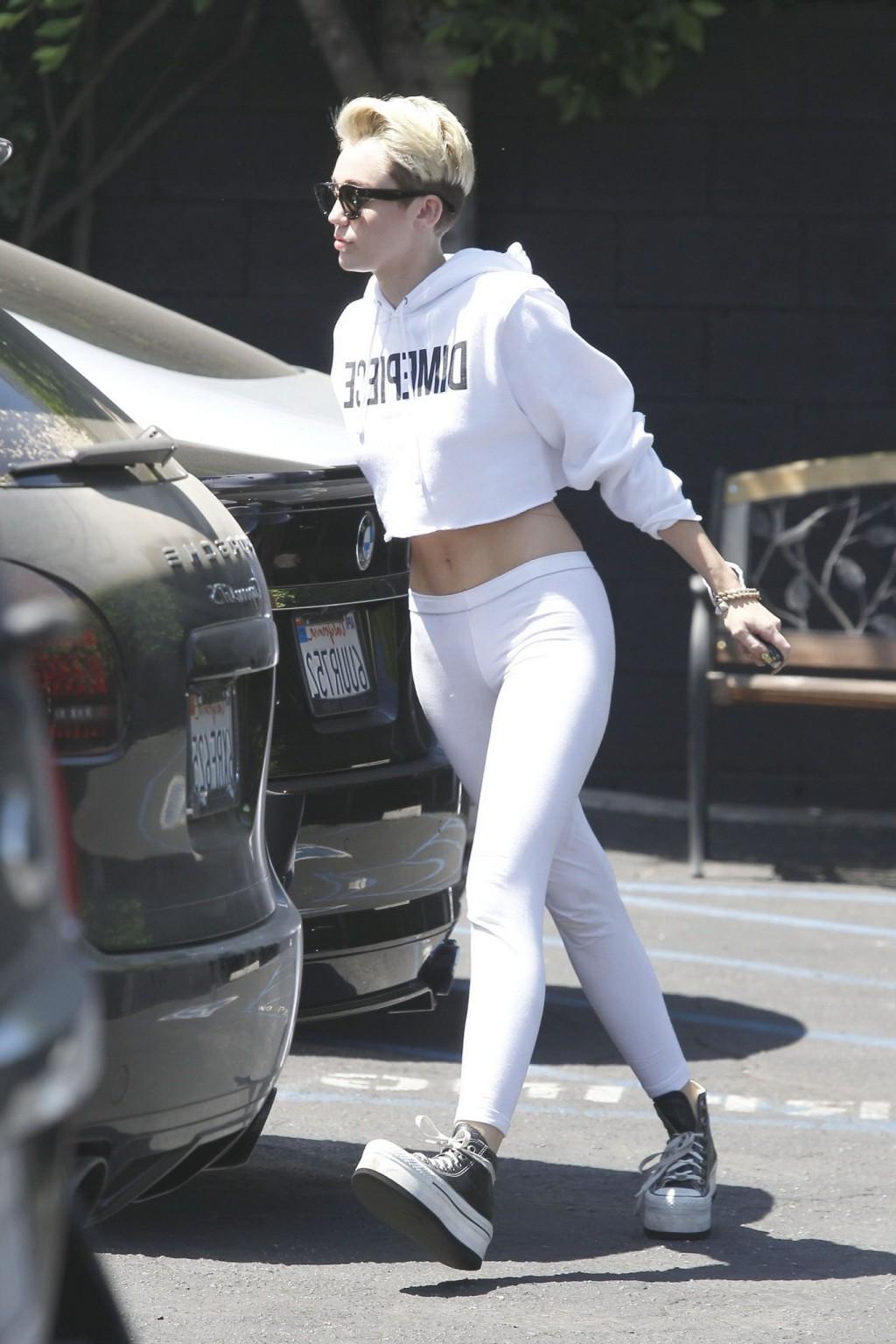 16P Miley Cyrus booty in white tights and belly top trying to hide from paparazzi ou