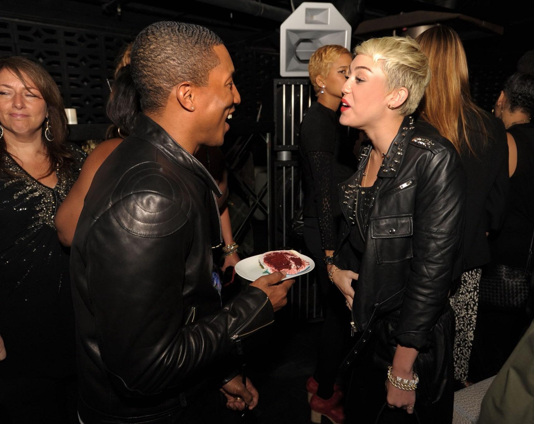 16P Miley Cyrus wears black belly top and leather shorts at Pharrell Williams's birt