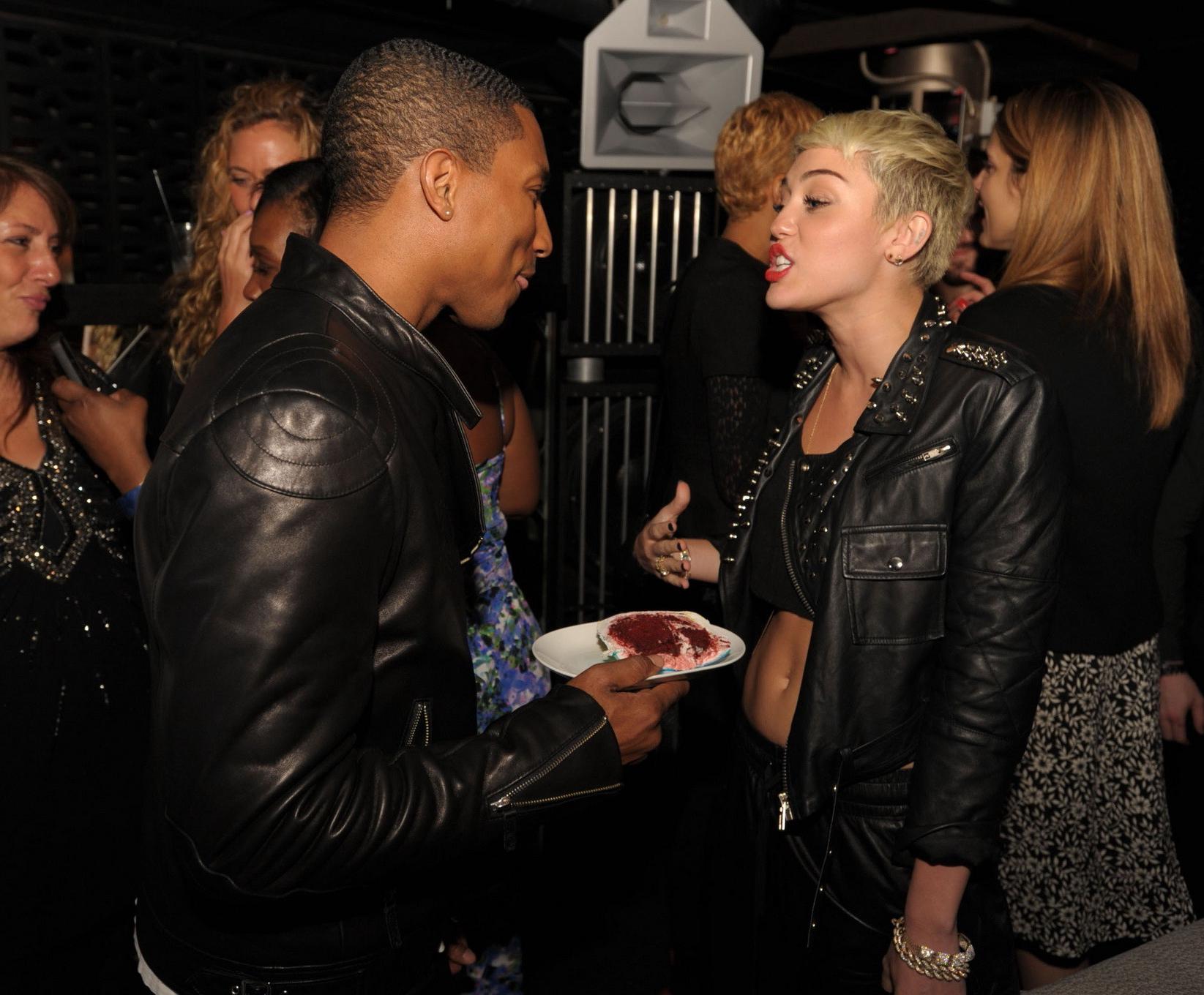 16P Miley Cyrus wears black belly top and leather shorts at Pharrell Williams's birt