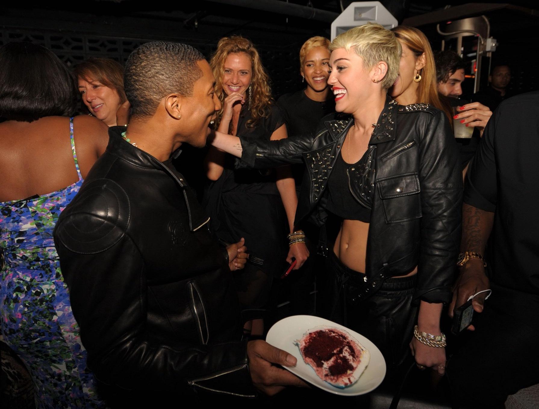16P Miley Cyrus wears black belly top and leather shorts at Pharrell Williams's birt