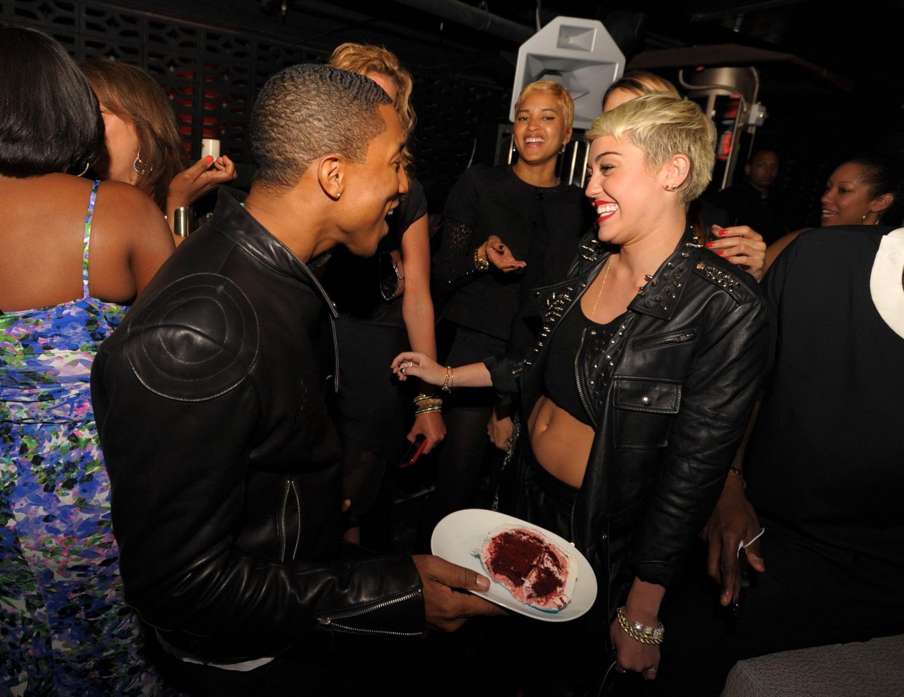 16P Miley Cyrus wears black belly top and leather shorts at Pharrell Williams's birt