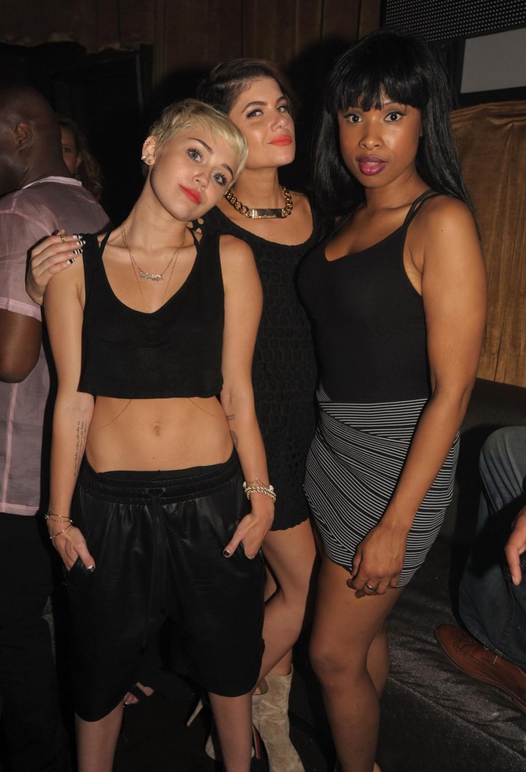 16P Miley Cyrus wears black belly top and leather shorts at Pharrell Williams's birt
