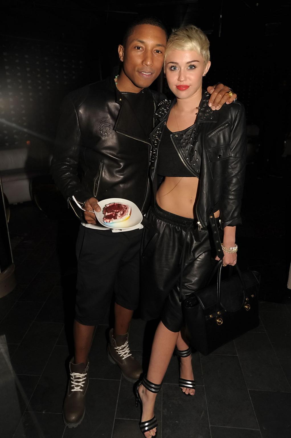 16P Miley Cyrus wears black belly top and leather shorts at Pharrell Williams's birt