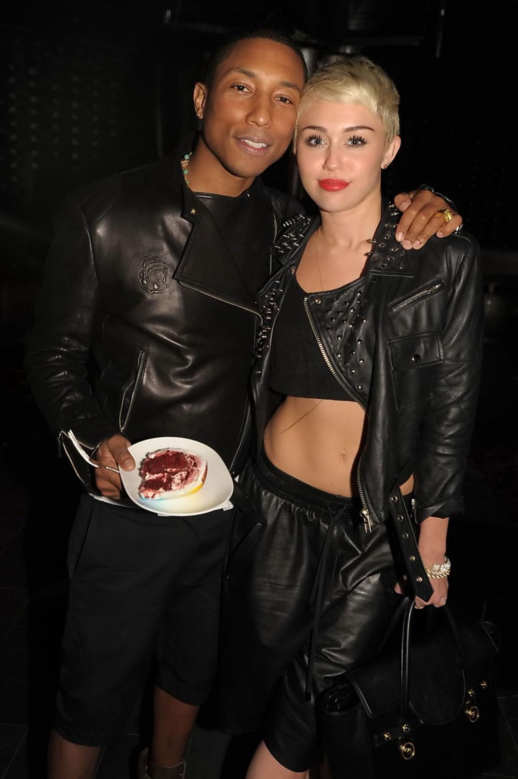 16P Miley Cyrus wears black belly top and leather shorts at Pharrell Williams's birt