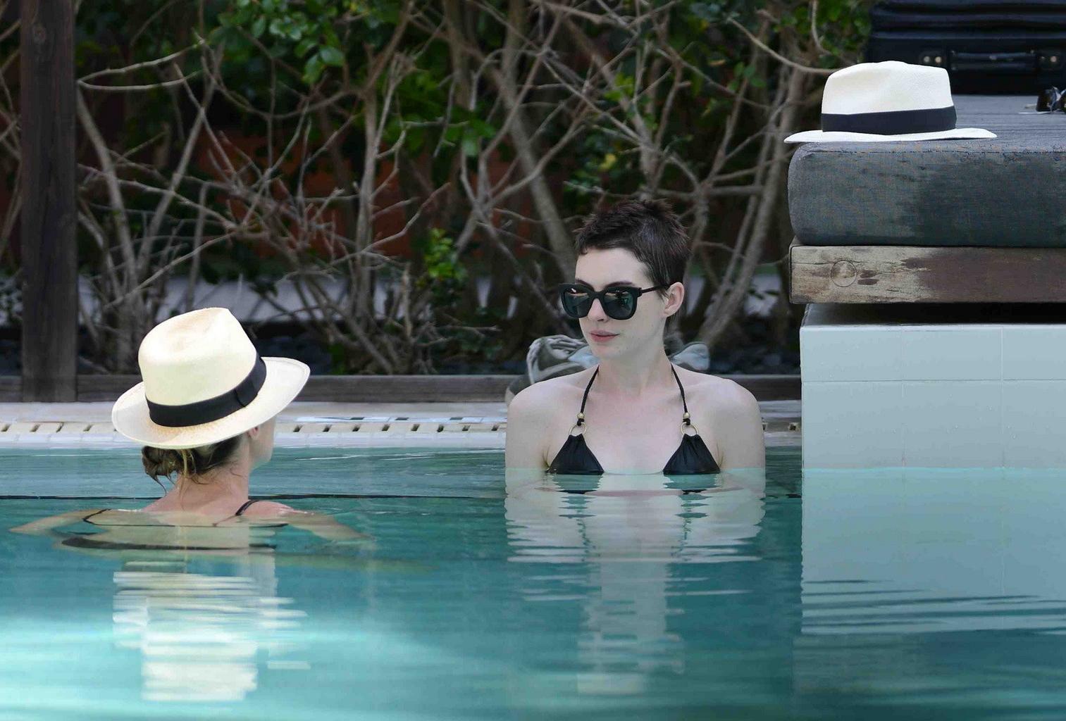 10P Anne Hathaway wearing wet black bikini at the Setai hotel pool in Miami