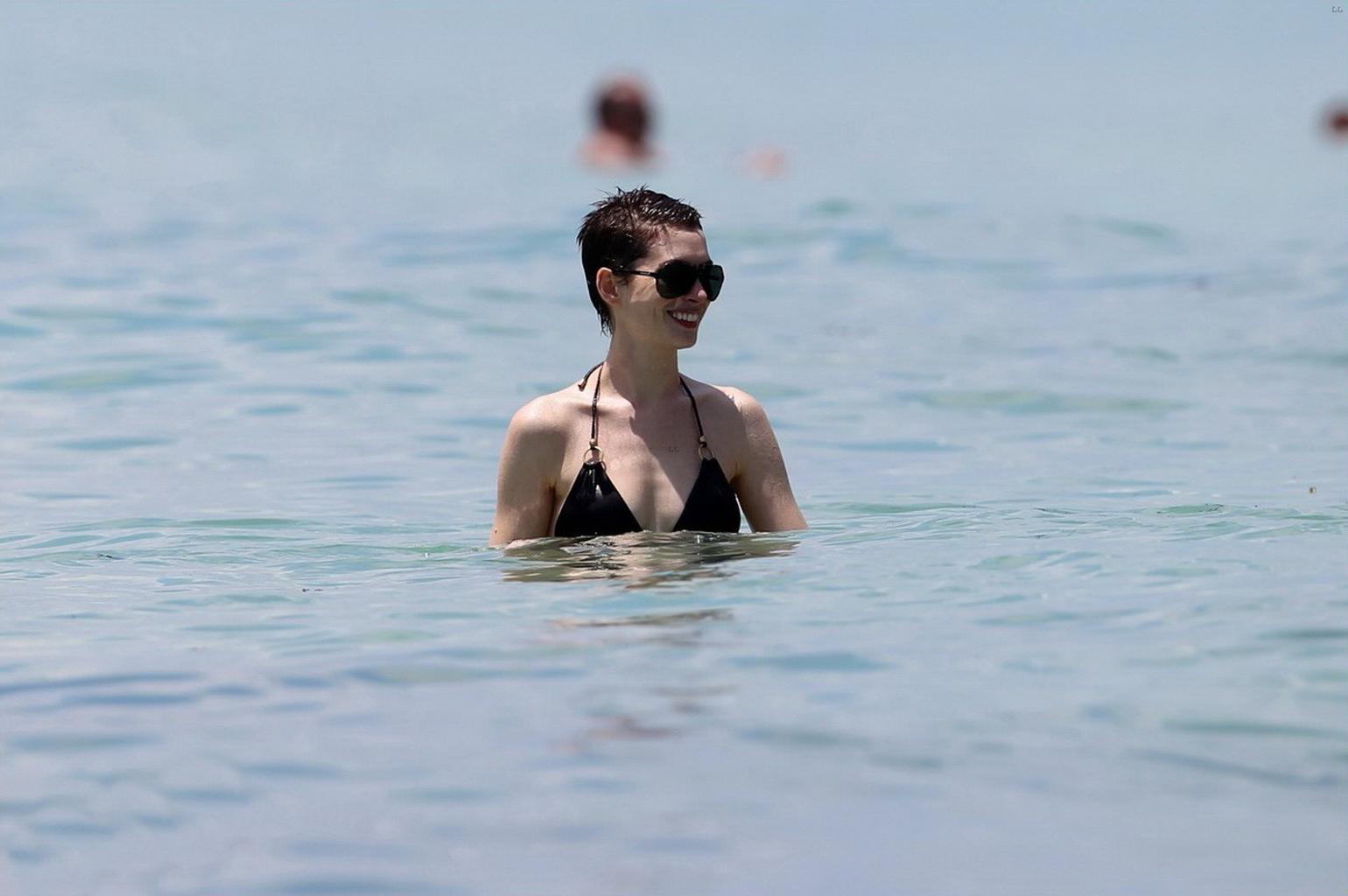 10P Anne Hathaway wearing wet black bikini at the Setai hotel pool in Miami