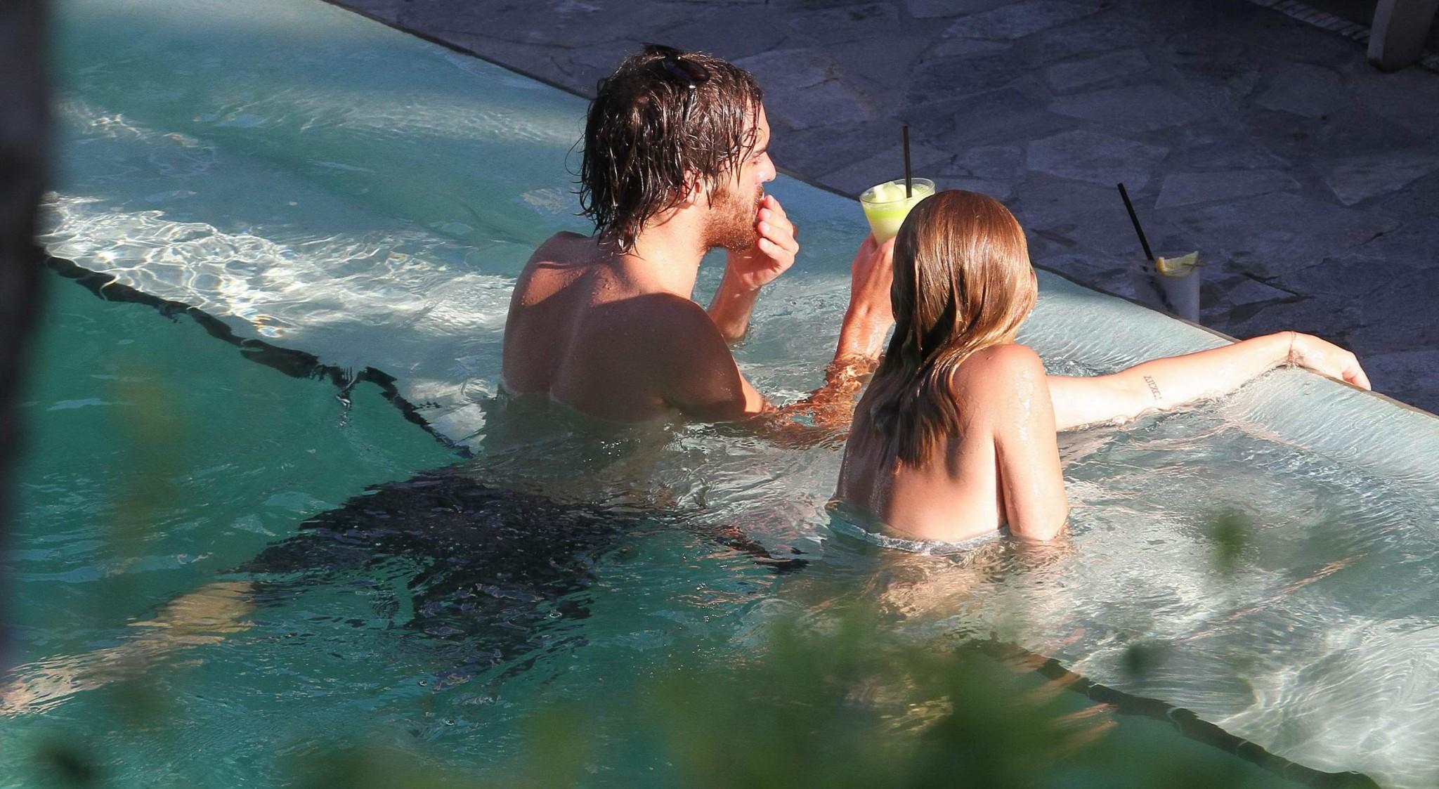 10P Miley Cyrus wearing white bikini at a hotel pool in Miami