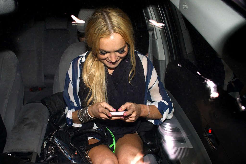 16P Lindsay Lohan en mini-jupe et jupe haute en voiture et seins nus.