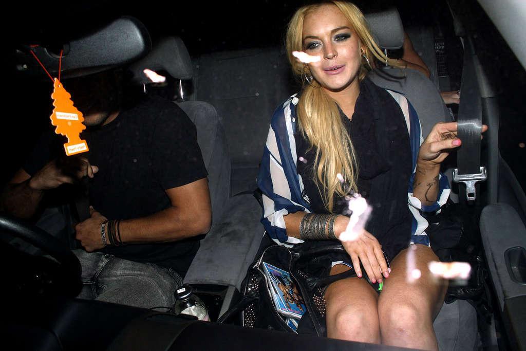 16P Lindsay Lohan en mini-jupe et jupe haute en voiture et seins nus.