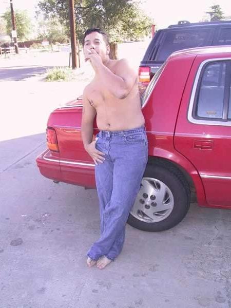 13P Amature guy posing by his red car
