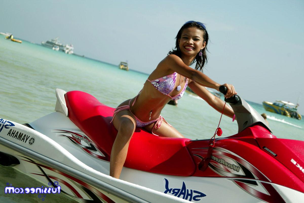 15P Asian teen model at the beach poses on a Jet Ski